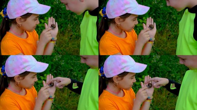 孩子们用放大镜看着蜗牛，有选择的焦点。孩子。