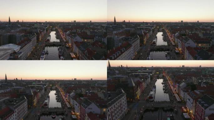 黄昏时城市景观的鸟瞰图。向前飞行在Nyhavn，繁忙的旅游街上，有娱乐。丹麦哥本哈根