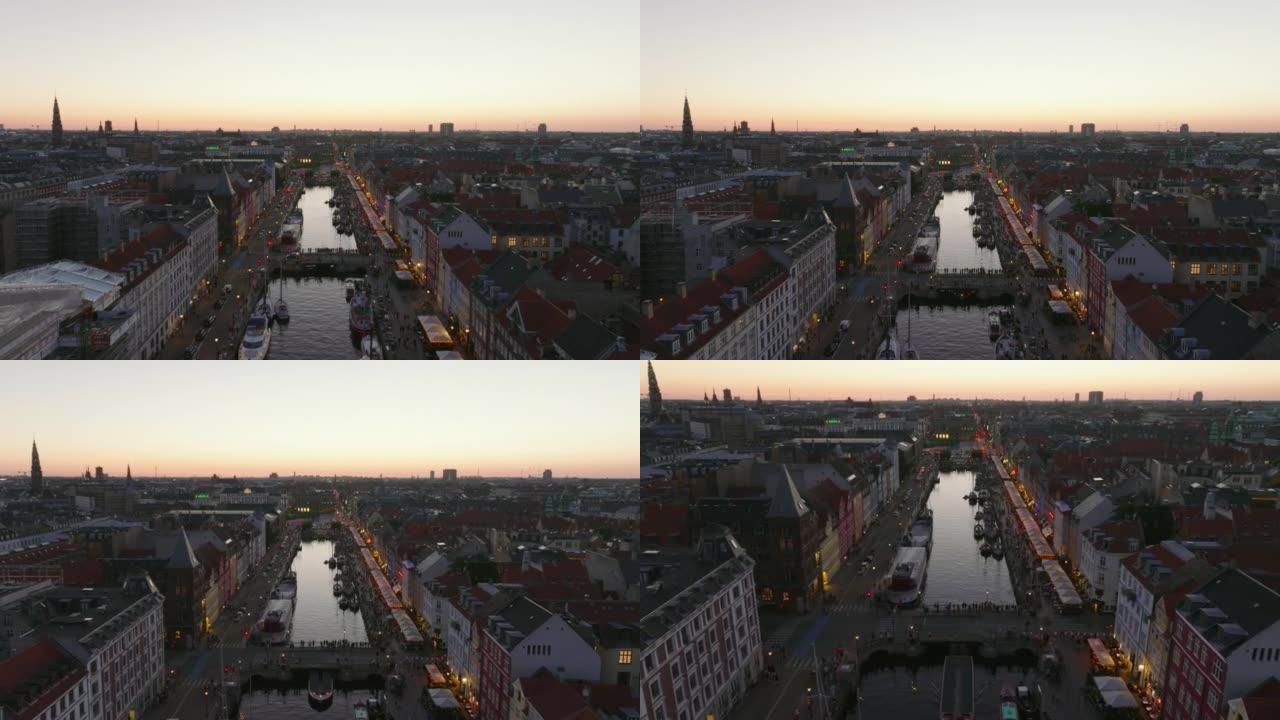 黄昏时城市景观的鸟瞰图。向前飞行在Nyhavn，繁忙的旅游街上，有娱乐。丹麦哥本哈根