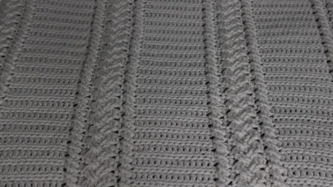 钩针编织毛毯的表面，编织成米色棉线，上面再铺一条白色毛毯
