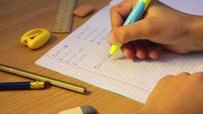 学生的手在笔记本上解决数学示例，特写镜头。