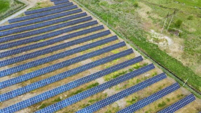 绿地上太阳能发电厂的鸟瞰图。带有用于生产清洁生态能源的面板的电力农场
