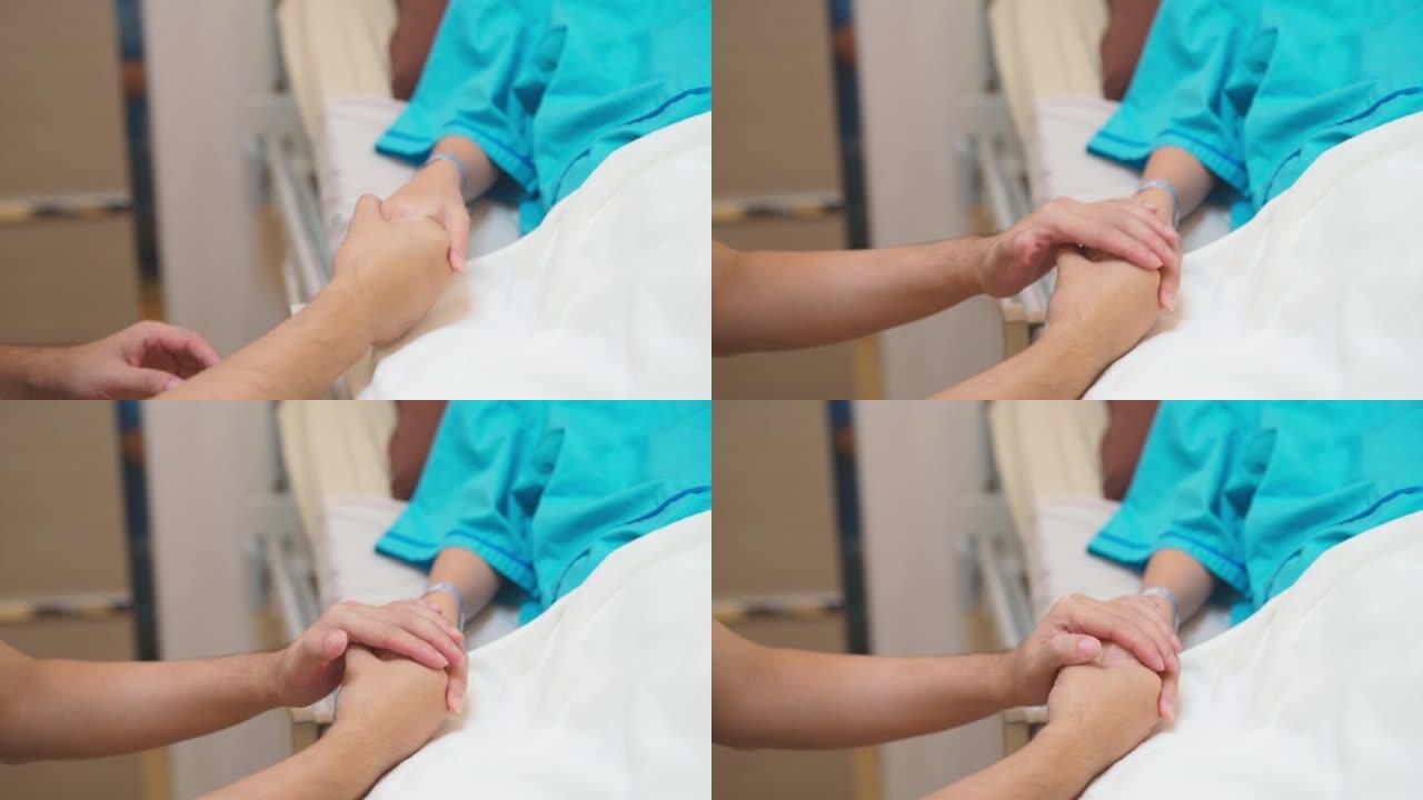 丈夫握住并抚摸他的手，妻子昏迷不醒，躺在医院病房的床上。亚洲女性患者用生理盐水溶液。医疗保健和医疗，