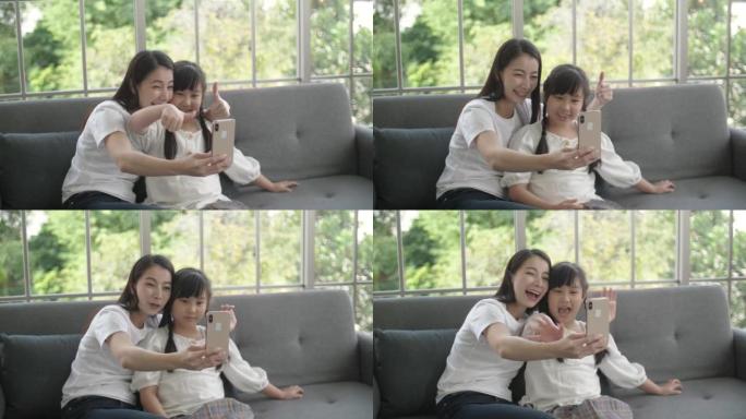快乐的家庭，母亲和女儿视频电话给父亲