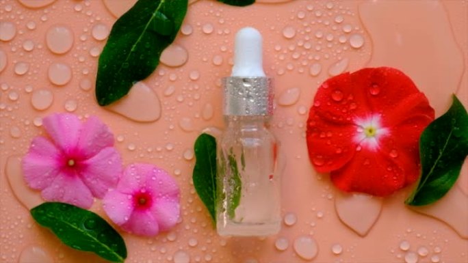 背景与水滴化妆品在瓶子和鲜花。透明质酸。Spa。