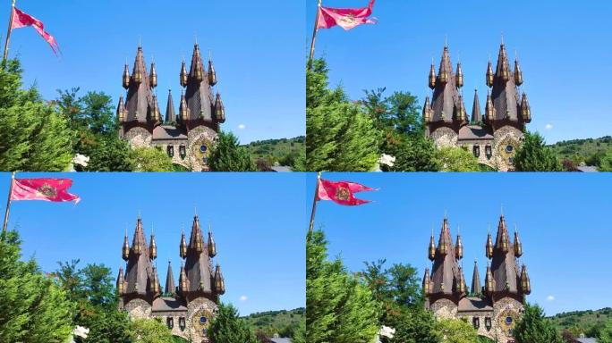 幻想宫殿，黑色和金色的尖塔，在森林林间空地的树木后面，挥舞着史诗般的旗帜-童话中拉瓦迪诺沃中世纪城堡