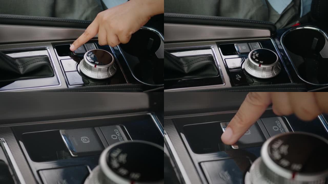 驾驶员手指按下驻车制动按钮。现代汽车自动驻车制动器。运输和车辆概念。