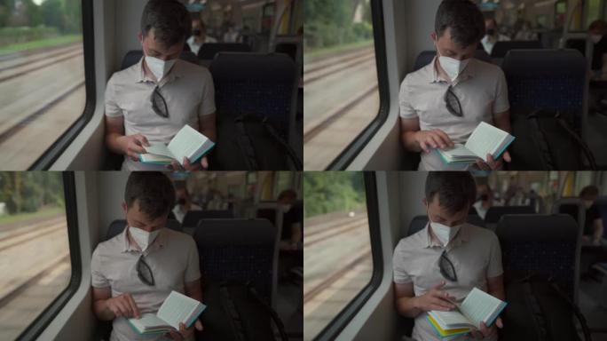 乘坐公共交通工具的乘客戴着防护口罩坐在窗户旁看书。一名男子戴着防护口罩在德国火车上旅行，看书。德国铁