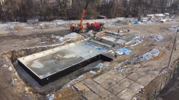 无人机在游泳池的建筑工地上架空，已经完成并用建筑粘合剂砌成砖砌的模板混凝土块，已经准备好并准备进行混