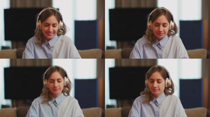 微笑的女工戴着耳机听音乐，在生产性工作日跳舞，坐在工作场所