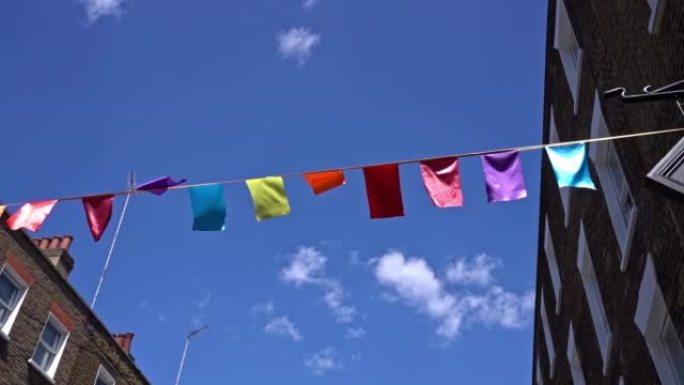 在蓝色阴天的夏日，在伦敦市的街道上挥舞着五颜六色的旗帜。