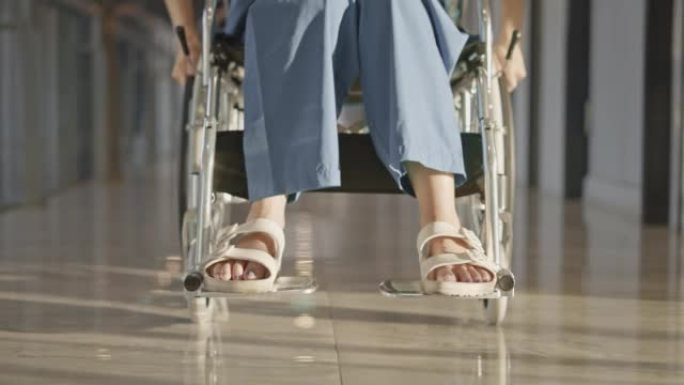 医院走廊上坐轮椅的女人，低角视角