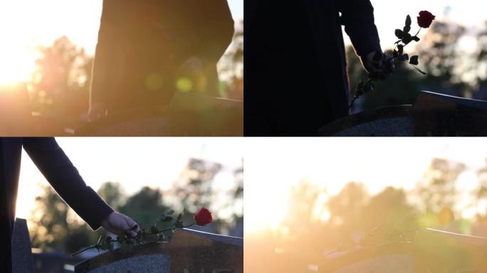 男人在墓碑上放花