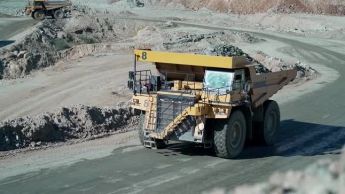 装载的卡车沿着铜，金矿露天矿床行驶，慢动作