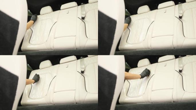 手清洁汽车座椅。一个人的手清洁豪华轿车的内部。