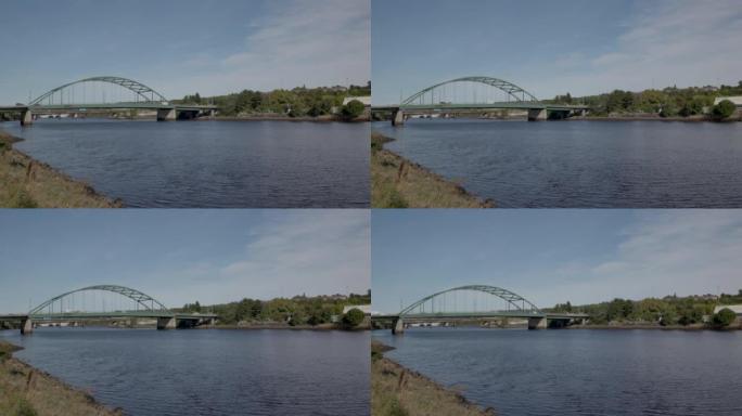 从布莱登的泰恩河看到泰恩斯科茨伍德大桥上的纽卡斯尔。晴天，蓝天轻云