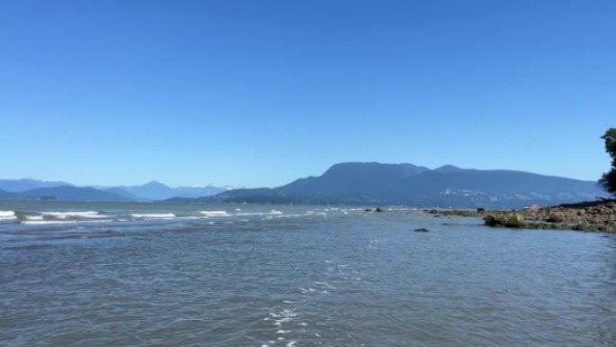 沉船海滩，塔海滩，阿卡迪亚海滩温哥华海滩在太平洋上慢慢摇拍，显示小波浪形成白色条纹的温哥华岛温柔的蓝