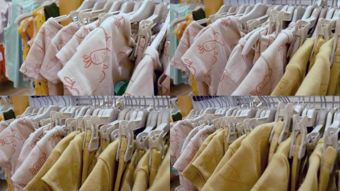 衣服新生儿挂在衣架上在服装店，儿童服装店的架子上。