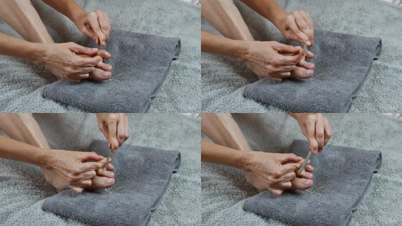脚指甲护理。一个女人用指甲锉擦指甲。
