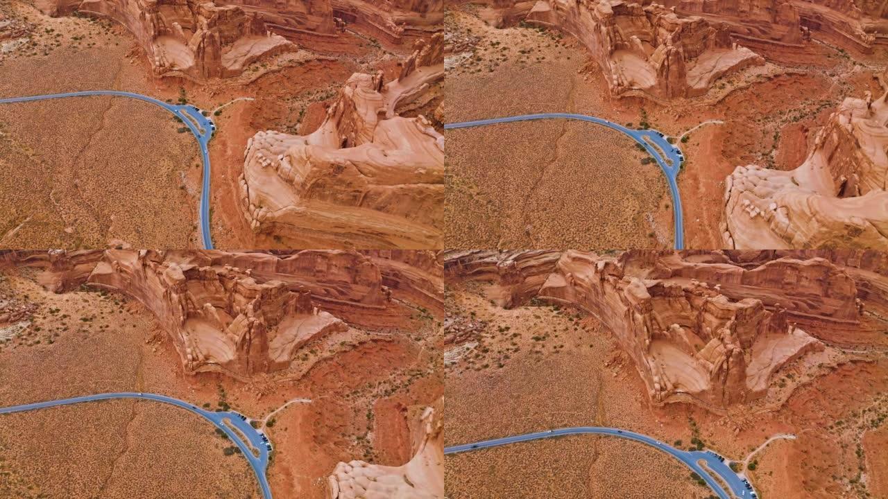 穿越红色干燥沙漠的公路灰色线。美国犹他州峡谷上空的无人机镜头。