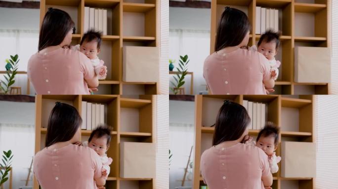4K，亚洲妇女抱着刚出生的女婴，在卧室里聊着下午让宝宝睡觉的好处。单身母亲正在照顾新生婴儿。