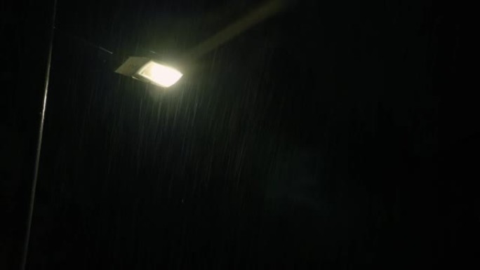 路灯背景上的夜雨。