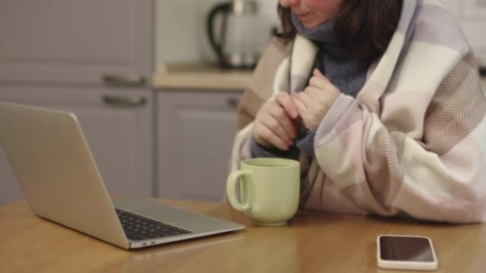 冷冻女人坐厨房包裹保暖毯保暖手握杯工作笔记本电脑