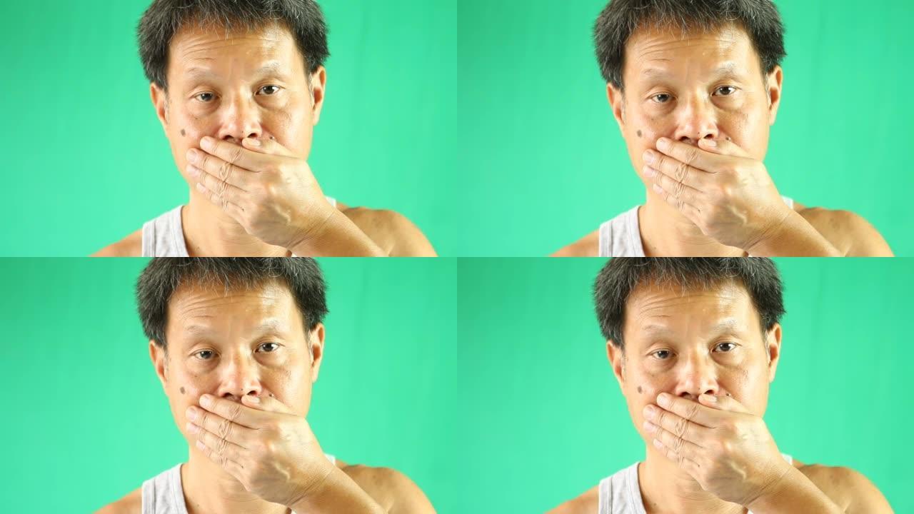 泰国男子用绿色背景闭上嘴