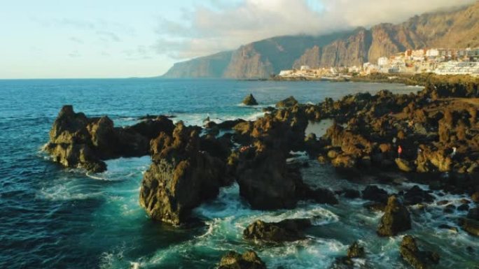 旅游景点。海浪和岩石上的空中日落光。特内里费岛、加那利岛、圣地亚哥港、夏科暗黑破坏神或自然魔鬼池。熔