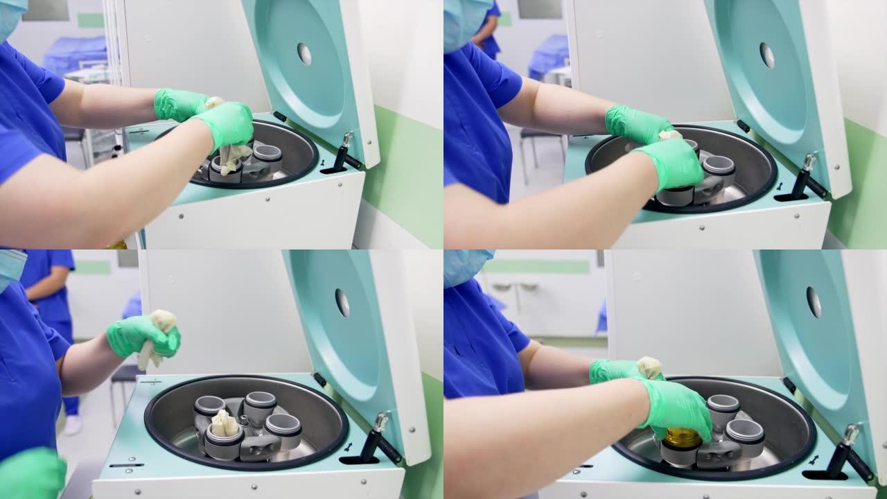 医院现代实验室的离心机。女护士的手将试管放在乳胶手套中，放入机器的储液器中。