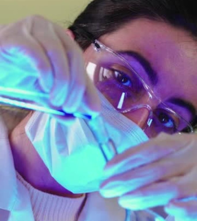 垂直视频，医学研究科学家在医学实验室的显微镜下观察。女微生物学家，与高科技设备一起工作。药学、生物化