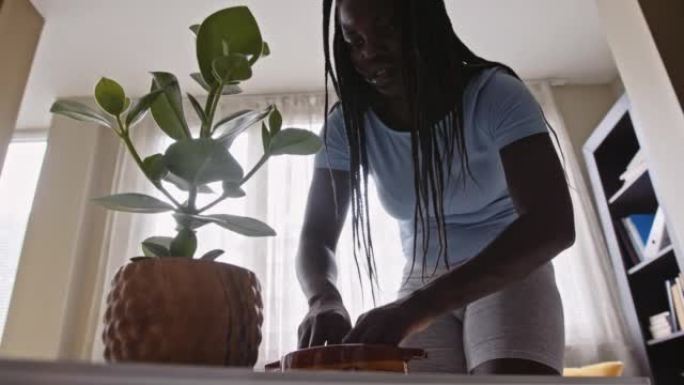 一名黑人女性一边在家做园艺一边拍短视频。