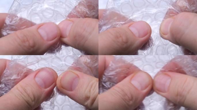 手指在保鲜膜上破裂气泡。抗压力源活性。包裹上粉刺的舒缓爆发