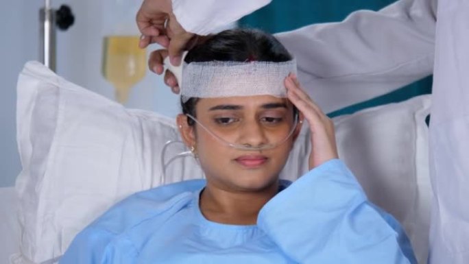 妇女在痛苦中得到绷带敷料对头部受伤的患者，身体伤害，伤口的治疗