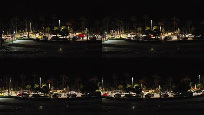 夜间度假小镇、堤岸和棕榈树。警察和运输