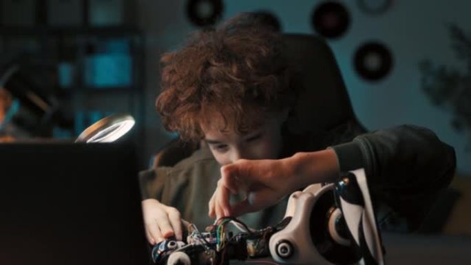 一个男孩的肖像在桌子上的房间里度过时光，修理机器人，拧螺丝以改善玩具的操作，对机械，电子，机器人技术