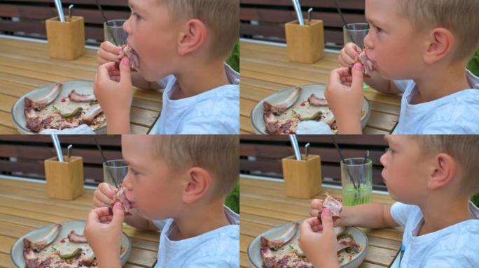 在餐馆吃肉的小男孩。4k慢动作录像