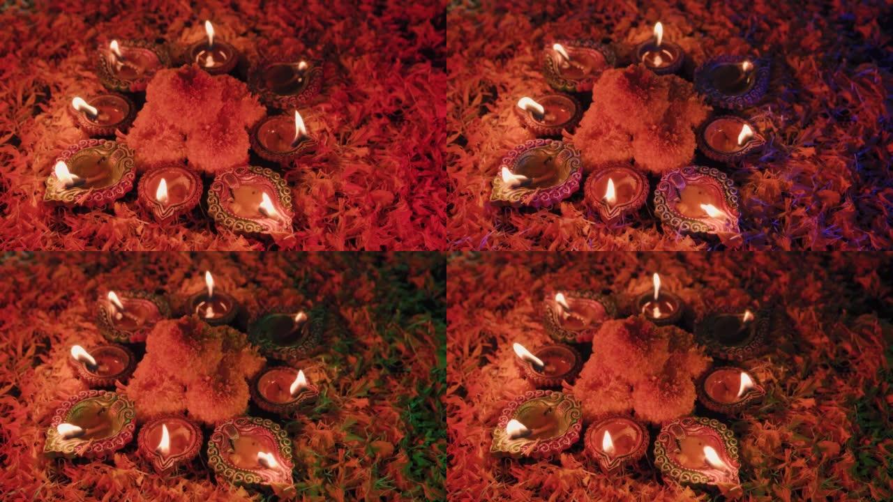 五颜六色的排灯节油灯，屠妖节油灯以美丽的形式点亮，中间有花朵，背景有不同的五颜六色的花朵，油灯闪闪发
