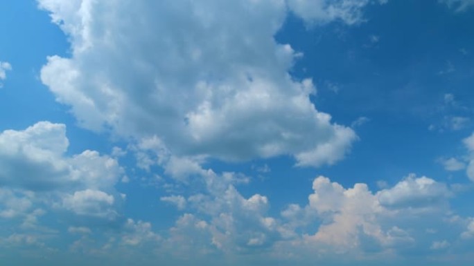 云在蓝天中移动。白天的热带天空，只有白色和蓝色。不同高度的半透明层。时间流逝。