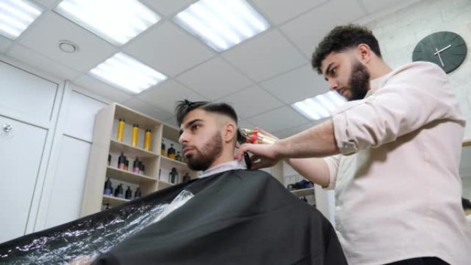 理发师用电动剃刀剪掉客户的头发。