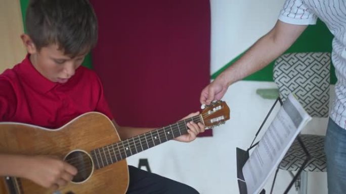 儿童在乐器握把方面从吉他老师那里得到帮助