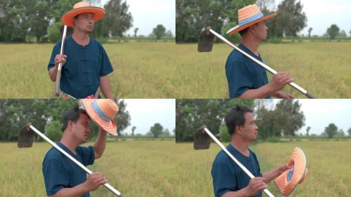 疲惫的亚洲农民男子脱帽拿铁锹
