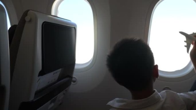 亚洲男孩在飞机上玩飞机玩具