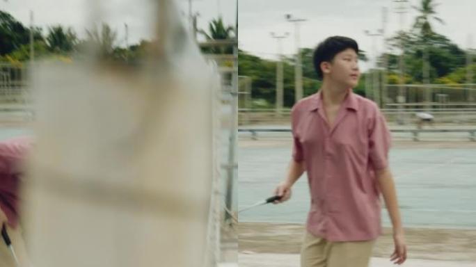 亚洲少年男孩和他的3个姐妹一起在室外球场打羽毛球，生活方式理念。