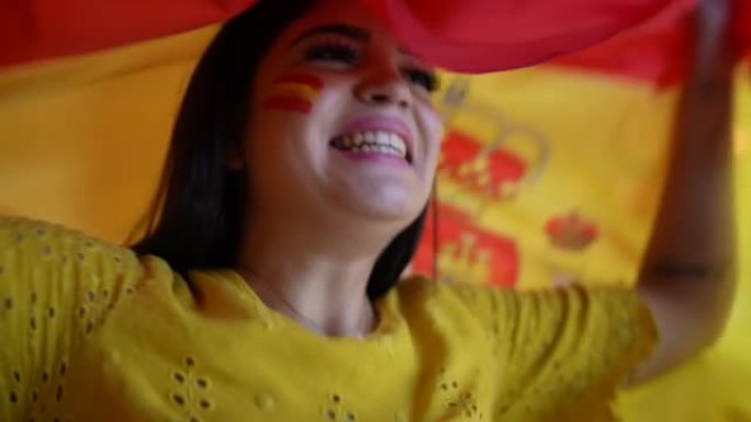年轻女子挥舞西班牙国旗庆祝