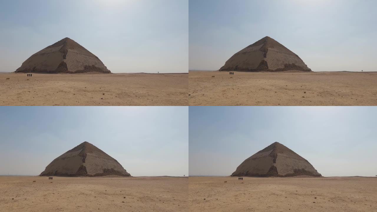 达什 (Dashur) 的古代Sneferu Bent金字塔的景色，人们在金字塔边行走