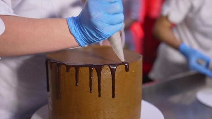 用液体巧克力装饰蛋糕。融化的巧克力从蛋糕里流下来。特写。