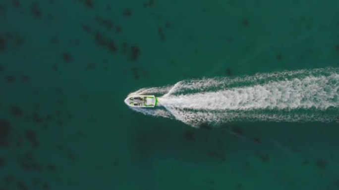 空中无人机飞越了船。带波浪的泡沫痕迹