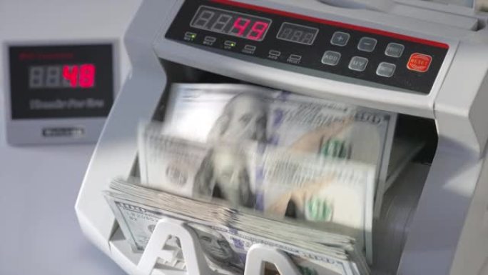 用于银行操作的自动提款机现代设备计数100美元的钞票。特写。