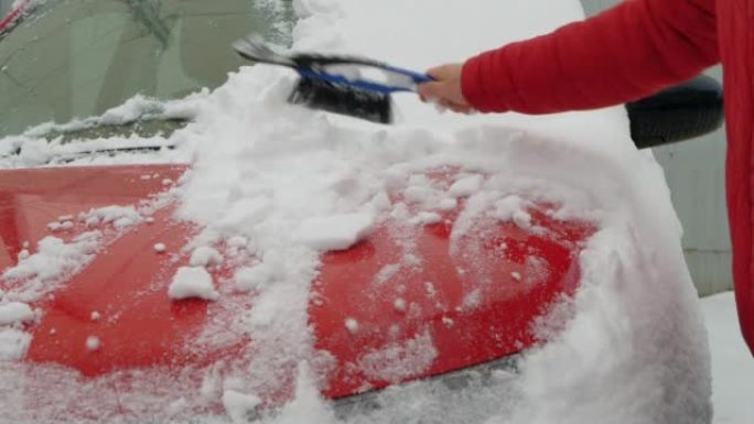 冬天用刷子清洁汽车发动机罩，以防雨雪